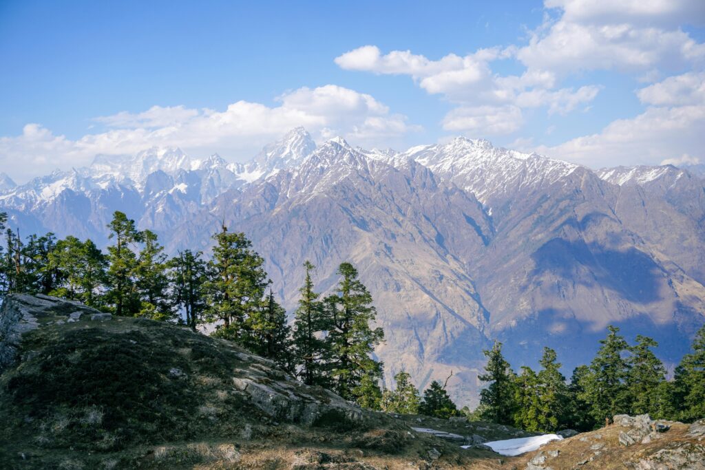 Breathtaking view of the Himalayan mountains in Salud Dugra, Uttarakhand, India, surrounded by lush trees.